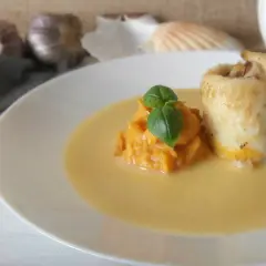 Roladka rybna z puree z dyni, udekorowana bazylią, podana w kremowym sosie beurre blanc.