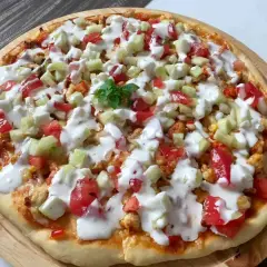 Domowa pizza z kurczakiem, pomidorami, ogórkiem i sosem jogurtowym.