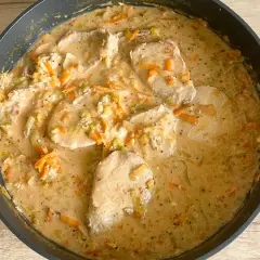 Schab w sosie porowo-marchewkowym, gotowy do podania. Aromatyczne kawałki mięsa w kremowym sosie z warzywami.