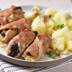 Pieczone schabowe z pieczarkami, zawinięte w boczek, podane z ziemniakami i natką pietruszki. Pyszny obiad gotowy!