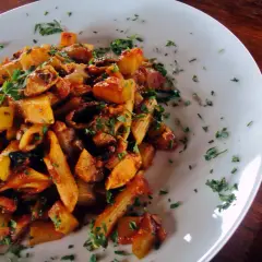 Penne z kurczakiem i cukinią w sosie pomidorowym, posypane natką pietruszki. Pyszne danie na obiad.