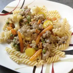 Makaron z mięsem mielonym i warzywami na patelnię: fusilli z mielonym mięsem, marchewką, groszkiem i kalafiorem.