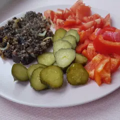 Kaszanka z cebulką, ogórki kiszone, pomidory i papryka. Czy można jeść surową kaszankę? To pytanie pozostaje otwarte.