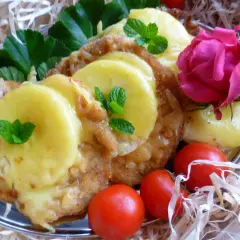 Schab po hawajsku z ananasem, zapieczony z serem, ozdobiony miętą, różą i pomidorkami.