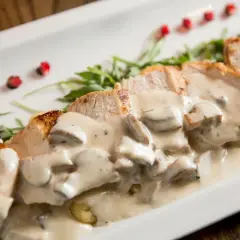 Kawałki kurczaka w kremowym sosie pieczarkowym, z dodatkiem ziół i pestek granatu. Idealny pomysł, co dodać do sosu pieczarkowego.