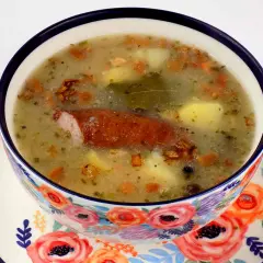 Jak zrobic zalewajke? Aromatyczna zupa z kiełbasą, ziemniakami i majerankiem w ozdobnej miseczce.