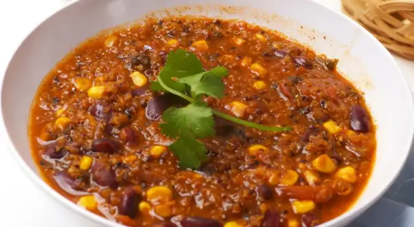 Gęste, aromatyczne chili sin carne z fasolą, kukurydzą i komosą ryżową, udekorowane świeżą kolendrą. Pyszne i sycące danie.