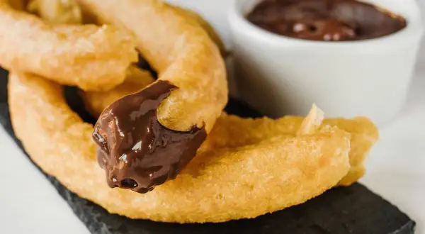 Churros z czekoladą, idealne do nauki jak zrobić churrosy. Pyszne, złociste i gotowe do zanurzenia.