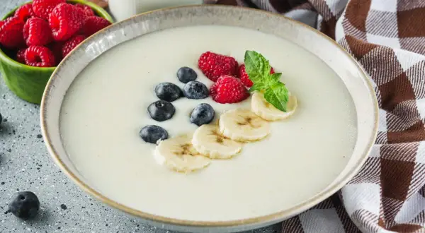 Miseczka kremowej kaszy manny z malinami, borówkami i bananem. Idealna na śniadanie, zastanawiasz się, ile kaszy manny na litr zupy?