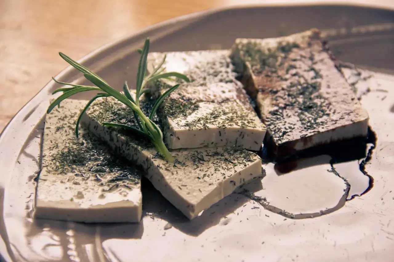 Pokrojone w kostkę tofu, posypane ziołami i polane sosem. Idealne, gdy zastanawiasz się, jak zrobić tofu.
