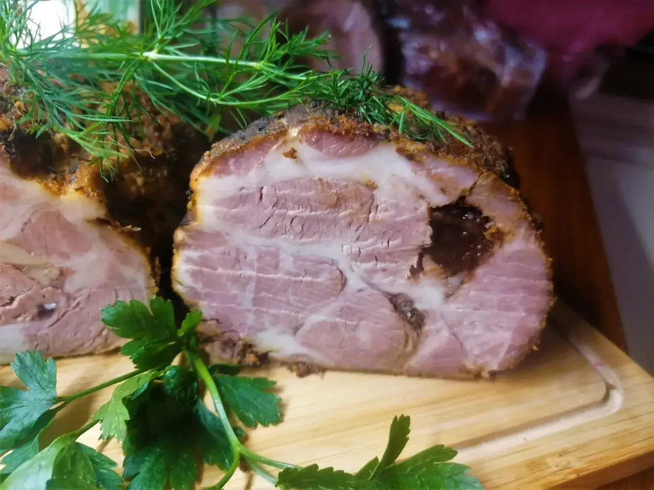 Soczysta karkówka ze śliwką, pieczona z ziołami, prezentuje się apetycznie na desce.